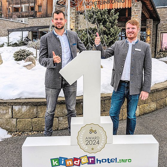 Foto kinderhotel.info: Florian Mayer (Geschäftsführer Familux Resorts, links) und Hoteldirektor Gerrit-Hendrik Bauer vor dem Familux Resort Dachsteinkönig in Gosau.